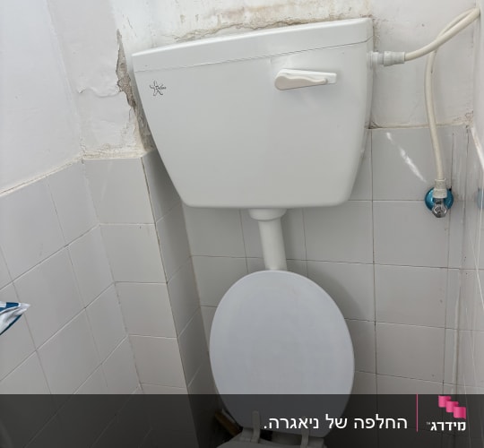 אסלה ומיכל הדחה בחדר שירותים